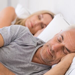 Adultos descansando em uma cama durante a noite.