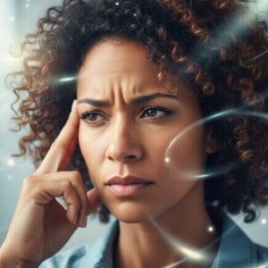 Mulher com expressão pensativa, tocando a têmpora em um ambiente com luzes suaves. Representa a clareza mental.