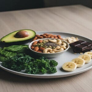 Prato com abacate, couve, espinafre, oleaginosas, aveia, chocolate e banana.