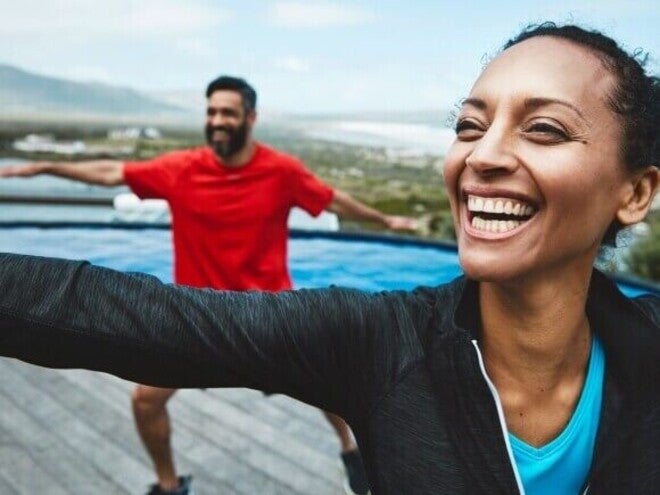 Adultos realizando exercícios de mobilidade ao ar livre.