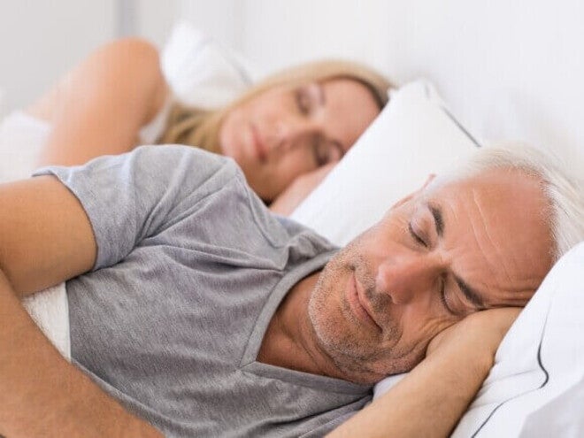 Adultos descansando em uma cama durante a noite.