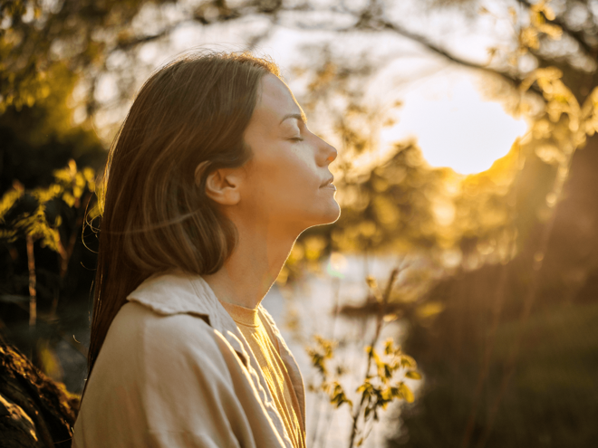 Mulher ao ar livre respirando com intenção.
