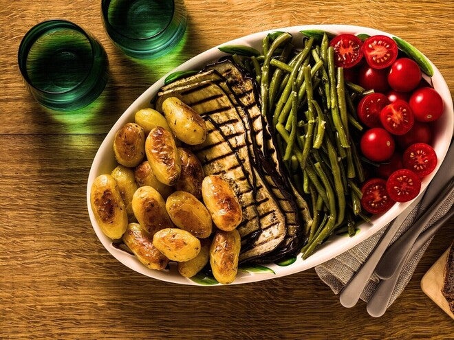 Travessa com batatas assadas, tomate e aspargos