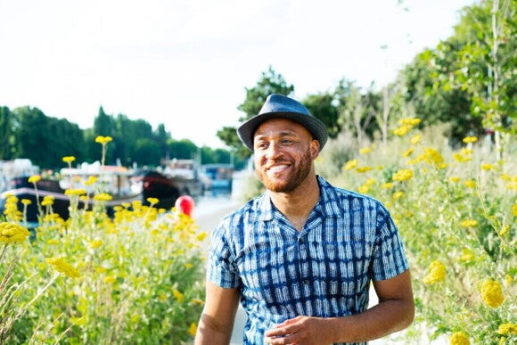 Homem feliz ao ar livre, aproveitando a luz solar para favorecer a produção natural de vitamina D.
